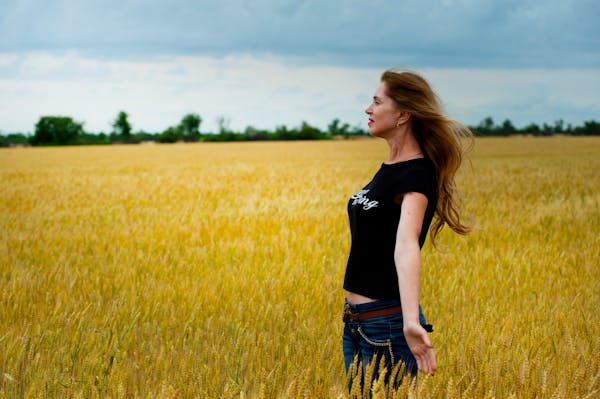 Cognitive Behavioral Therapy: 7 Powerful Ways CBT Can Transform Your Mindset 3 Woman standing in an open wheat field, embracing calm and freedom—symbolizing the emotional clarity and peace achieved through Cognitive Behavioral Therapy.